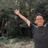 森の中で両手を広げる、無料シェアハウスの仕組みをつくった堀口尚志さん
